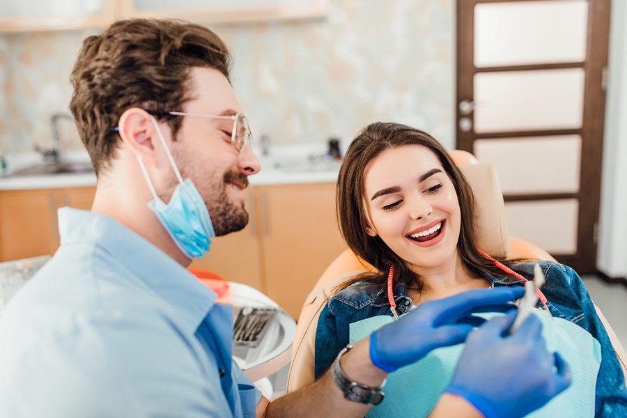 Dentist matching colour of the tooth enamel with whitening chart.