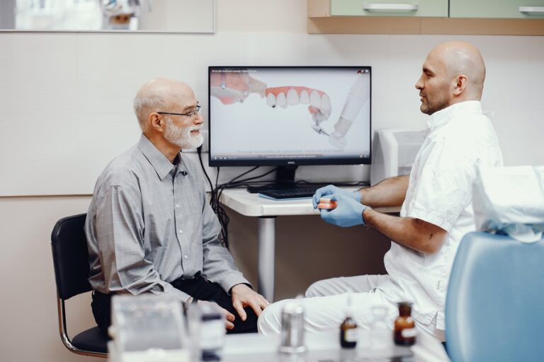 Handsome old man talking to the dendist. Two man in the dentist's office